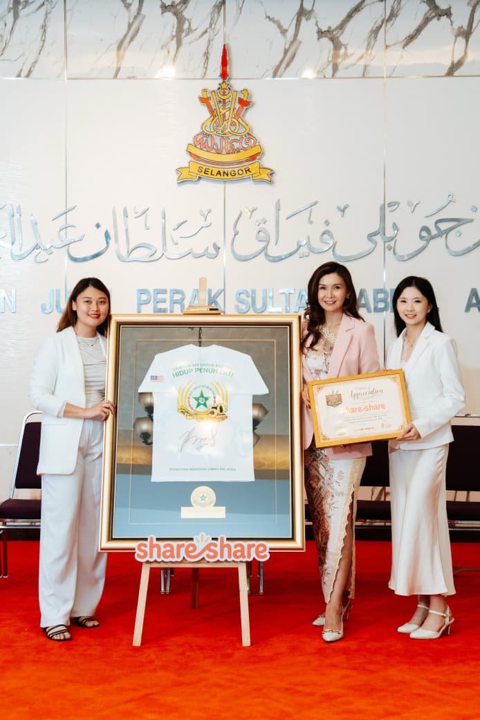 The three ShareShare founders beside a framed signed jersey, one holding a certificate of appreciation
